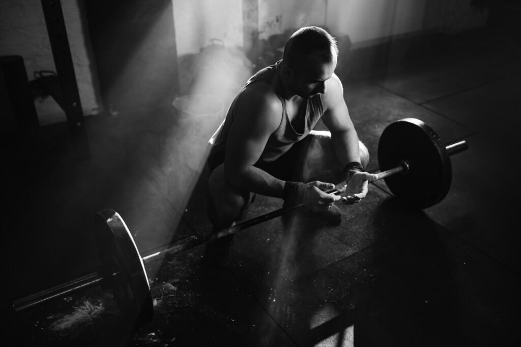 Lifter chalking his hands before a heavy barbell lift