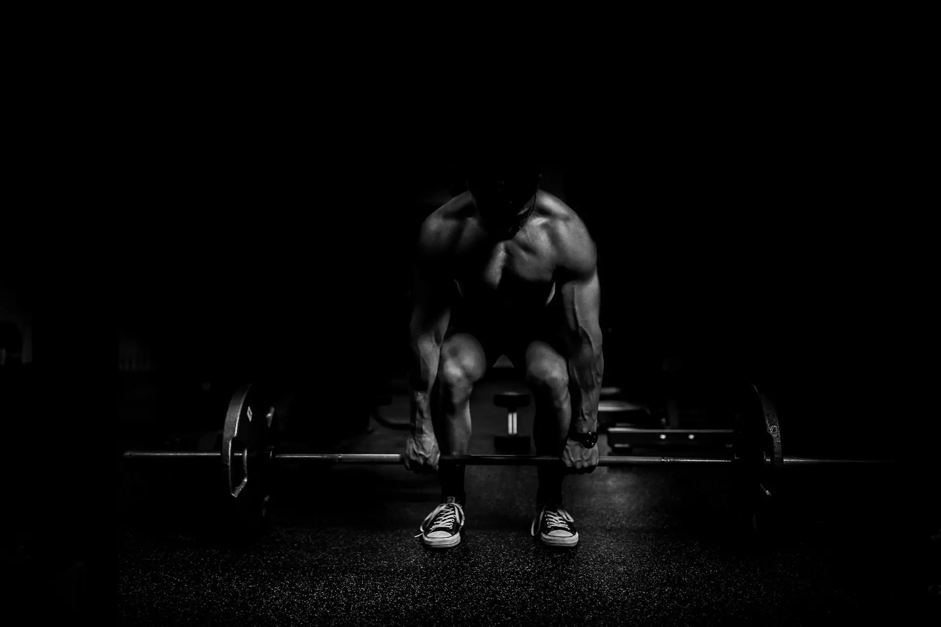 Athlete preparing for a heavy deadlift in a dark gym